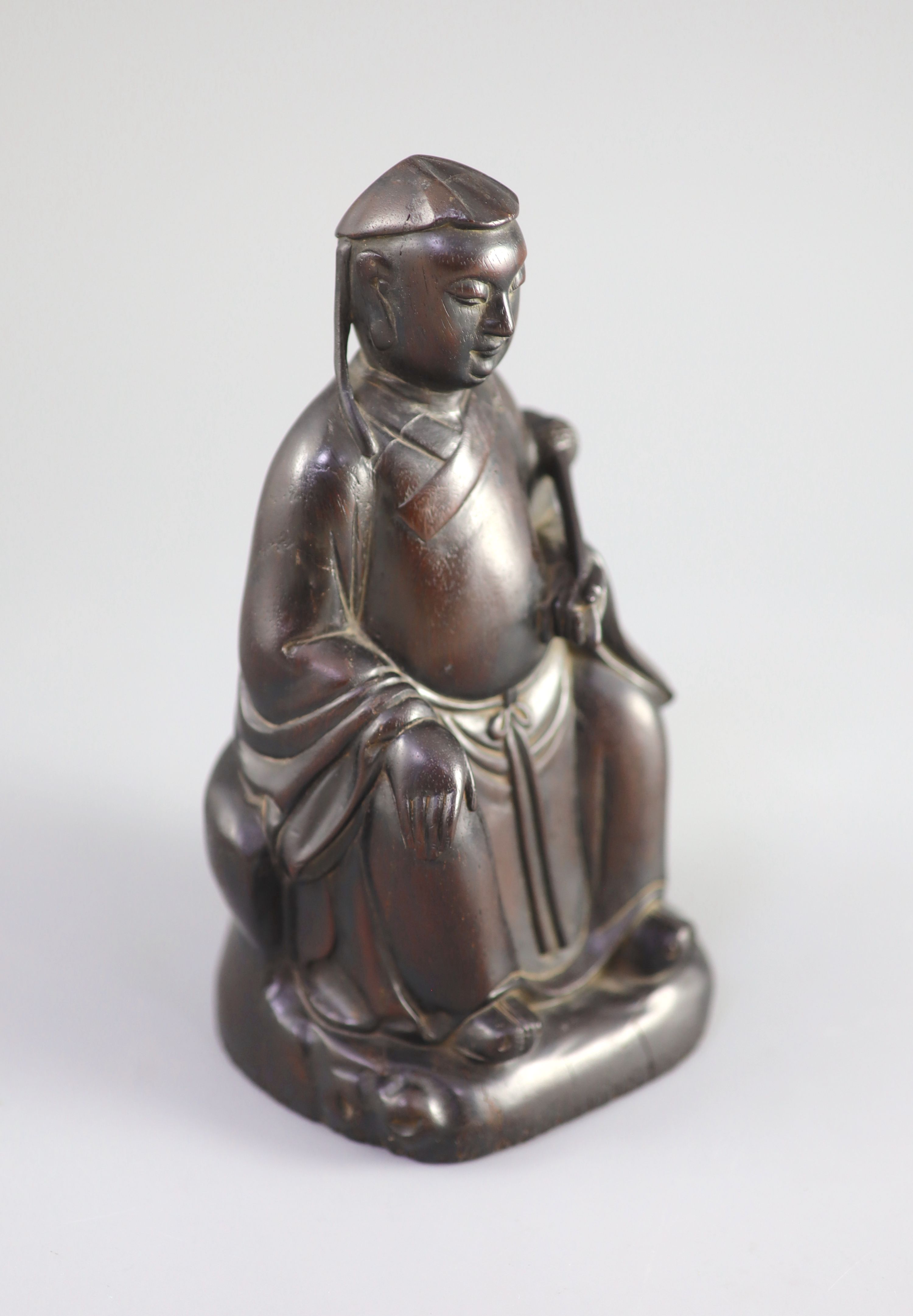 A Chinese Zitan seated figure of an official, 18th century, 19.3cm high